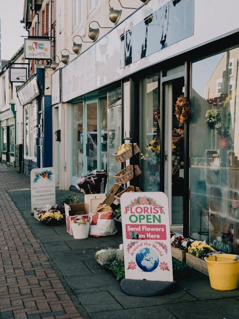 Outside flower shop on Station Road Gerrards Cross with a display of floral arrangements and potted plants. The shop's large glass windows showcase vibrant bouquets and floral decorations inside. On t