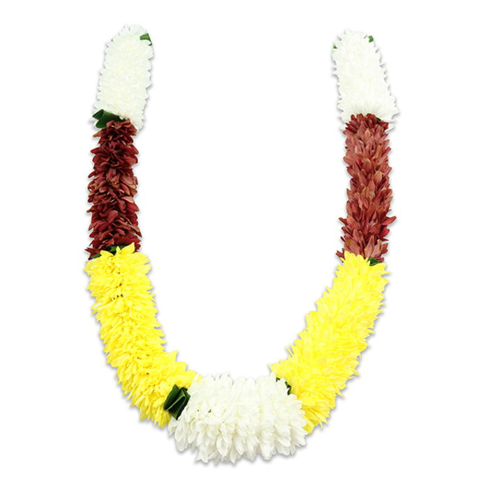 A richly coloured, U-shaped ceremonial garland is presented on a stark white plane so its construction and hues stand out clearly. The garland is artificial-composed of innumerable fabric petals arranged in dense, cylindrical clusters-beginning at each top end with substantial sections of creamy white blooms that read as small chrysanthemums or jasmine-inspired puffs. Directly beneath these white caps sits a tightly packed band of maroon to reddish-brown, its tone lending depth and tradition to the upper curve. The design then opens into an extended, plump band of sunny yellow flowers that shape the generous middle-to-lower arc of the 'U', their fluffy texture suggesting marigolds in miniature and creating the garland's most visually dominant plane. At the very lowest point, a wider cluster of pure white chrysanthemum-like flowers unites the two sides and becomes the composition's natural focal heart; interspersed dark green leaf-like accents subtly mark colour transitions and provide a measured natural counterpoint. The craftsmanship is evident in the even density and layered arrangement of the petals, producing a textile-like surface and a stable, ceremonial weight. Although artificial, the piece is ideally suited to ritual use-pooja, temple offerings, weddings, or festivals such as Diwali and Holi-and would sit respectfully at a local community event or family altar in Gerrards Cross, Beaconsfield, or nearby Farnham Common, communicating honour, welcome, and devotion through its time-honoured colour language.