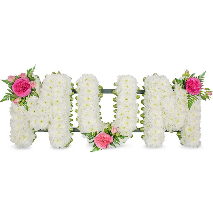 Displayed against a bright, uncluttered white background, this MUM floral tribute has a calm, composed presence, like a quiet pause in the midst of a busy day. Three capital letters stand side by side, each carefully formed from a sturdy frame that is completely covered by petite white spray chrysanthemums. The individual blooms are closely set, their tiny petals overlapping to create a continuous, velvety surface that looks almost like a soft quilt. The cool, clean white of the flowers suggests purity and remembrance, while the density of the petals gives the impression of great care and time invested in honouring one special person. A narrow line of dark green at the base of each letter hints at the supporting structure, adding a subtle outline and a ribbon-like finish. Colour is introduced with restrained, thoughtful touches: on the upper left point of the first M, there is a striking posy of fuchsia and light pink roses, threaded with airy fern foliage; at the base of the U, another similar spray is nestled, as if gently resting against the cushion of chrysanthemums; and on the upper right of the second M, a third matching cluster balances the composition. The fuchsia rose petals look ruffled and velvety, while the lighter pink buds add softness and promise. You can almost sense the gentle scent of roses mingling with the fresh, green note of fern. This is the type of bespoke funeral flower arrangement often delivered around Gerrards Cross for services at local churches or crematoriums, a deeply personal way for family and friends to say a final, loving thank-you to Mum.