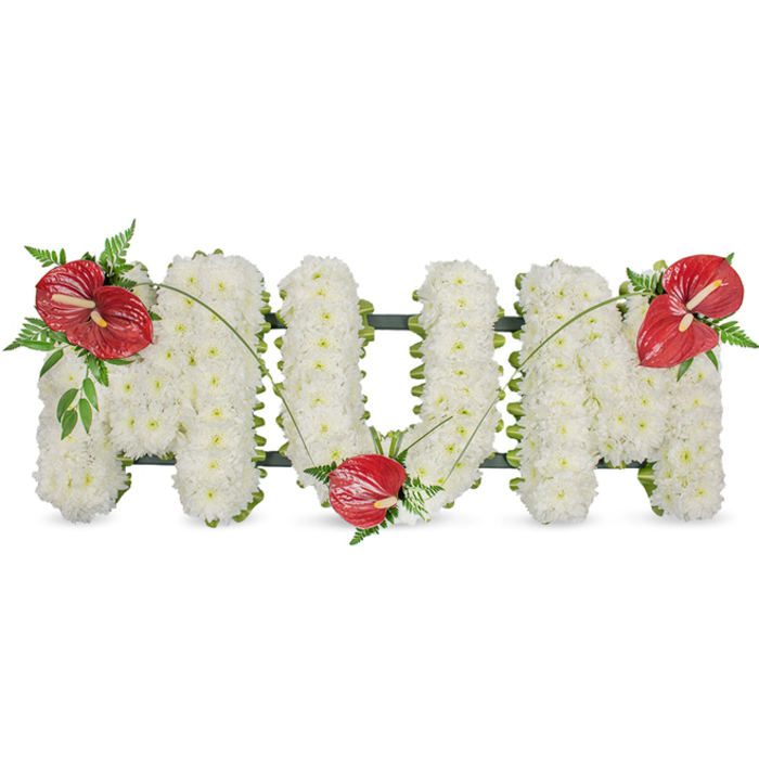 A poignant floral tribute spells 'MUM' in clean, capital letters, each character formed from a dense carpet of small white spray chrysanthemums that create a soft, pillowy texture across the face of the arrangement. The tight-packed blooms present a uniform, luminous white plane that feels both gentle and substantial, their dewy scent faint beneath the hush of daylight. Beneath this field a dark green structural frame is visible along the edges, giving the freestanding letters their crisp outline and steady posture. To punctuate the white with deep warmth, three vibrant red anthuriums have been positioned with considered symmetry: one placed on the upper left arc of the opening 'M', another set into the lower curve of the 'U', and a third gracing the upper right of the closing 'M'. Each anthurium, with its shiny, sculpted spathe and pale yellow spadix, is embraced by small clusters of dark foliage - delicate fern fronds, broader glossy leaves and long arching stems that add motion and botanical depth. Slender blades of grass link the red focal points, sweeping in a subtle horizontal rhythm that unifies the trio of blooms and softens the architectural letters. The overall mood is classic and consoling, a sympathetic tribute meant to honour a mother's memory with dignity and warmth. Locally, this style is often chosen for services around Gerrards Cross and the surrounding Chalfont villages, where families seek a tasteful, handcrafted expression of love and remembrance.