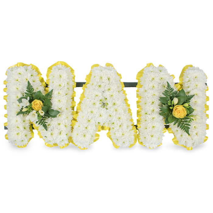 A lovingly crafted floral tribute spells MAM in three individual capital letters, each letter formed from a dense mass of small white chrysanthemum sprays that give the surface a soft, intricate texture like fine lace. The outer perimeter of every letter is finished with a bright, pleated yellow satin ribbon, the colour of new light, which crisply defines each letter against the plain white backdrop. Small clusters adorn the left upright of the first M and the right upright of the final M: a tightly furled yellow rose anchors each cluster, surrounded by delicate white freesia-like buds and an assortment of deep green foliage including slender fern fronds and glossy leaves, providing a refreshing contrast of tone and a natural, organic silhouette. Behind the upper sections a discreet dark green support bar joins the letters, indicating a stable easel-ready construction suitable for display at a funeral service, memorial, or graveside. The floral scent is gentle and reassuring-clean chrysanthemum notes with a whisper of rose-while the textures range from the soft, cushiony chrysanthemums to the satin ribbon and the smooth, cool foliage. As prepared for families in Gerrards Cross and nearby Beaconsfield, this arrangement reflects careful craftsmanship and thoughtful detail, made with respect for the occasion and the wish to celebrate a beloved mother with warmth, purity, and enduring affection. Flower Delivery Gerrards Cross can supply this personalised tribute for memorials across the town and surrounding villages with sensitivity and prompt attention.