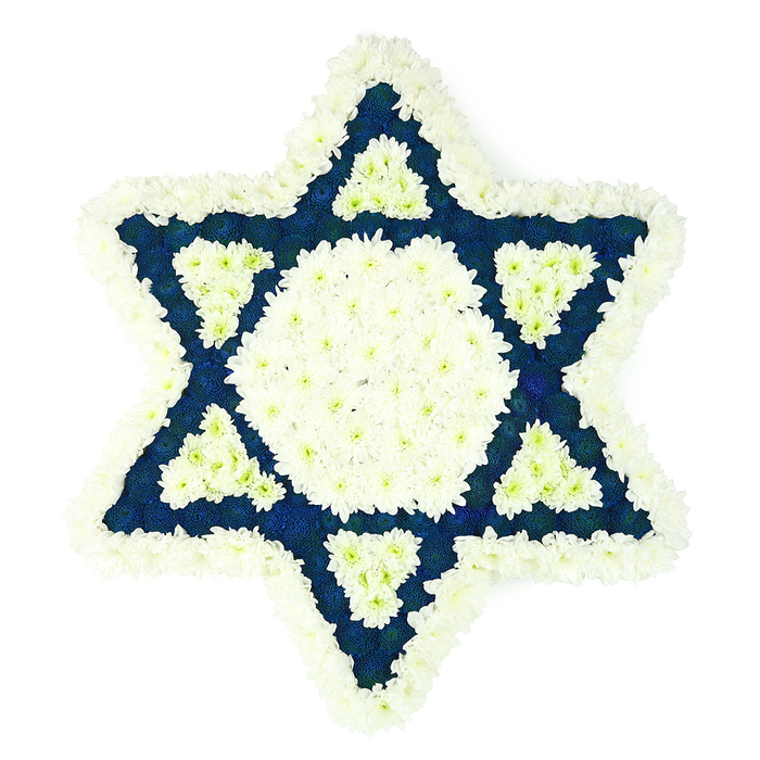 This image shows a large, deeply symbolic Star of David floral arrangement, photographed against a clean, white background so that every petal and colour contrast stands out with clarity. The Magen David is constructed with precision, the outer edges traced in a thick border of white chrysanthemums that creates a soft, ruffled frame around all six points. Just inside, a prominent central hexagon of the same snowy blossoms glows with brightness, forming a calm focal point at the heart of the tribute. From this centre, the six arms of the star stretch outward, each one filled with densely packed dark blue blooms in a velvety navy tone, similar to the deep blues sometimes seen in prayer shawls during services at local synagogues serving families from Gerrards Cross. At the inner base of each blue point, there is a smaller, neatly defined triangle of white flowers, creating a woven effect of white and indigo that repeats around the star. The interplay of the two colours-pure white and rich, solemn blue-gives the piece a reverent, ceremonial character that feels appropriate for Jewish funeral services, memorials, or shiva gatherings. No greenery is visible; the design is entirely floral and geometric, with the tight packing of blossoms ensuring that the star's lines remain crisp and mathematically true. The overall impression is one of quiet strength and consolation, like a floral emblem of faith and remembrance that might be delivered to a chapel of rest or family home in Gerrards Cross to honour a life lived with devotion and to bring a gentle sense of peace to those in mourning.