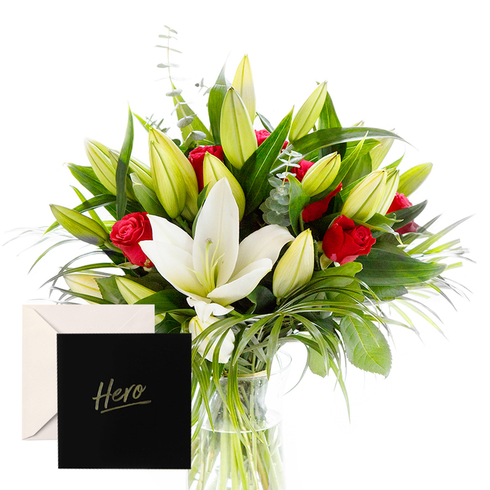 As a florist, there is joy in blending the bold with the serene, and this arrangement is a testament to that harmony. White lilies drift at the heart, luminous and airy, their satin petals contrasting with the tactile, lush greenery that encircles them. Rich red roses punctuate the design, each one a symbol of love and respect. Verdant leaves provide a forest-like backdrop, while unopened lily buds hint at anticipation and new beginnings. In soft, natural light, the bouquet feels alive and uplifting, perfect for honoring someone's strength or celebrating a significant achievement. The accompanying Hero card makes this gesture intimate and enduring.

For Gerrards Cross families and neighbours in Chalfont St Giles and Denham, the arrangement offers a refined, comforting presence-ideal for a home or office that needs quiet encouragement or a moment of gratitude. Our florists craft it with careful spacing, giving each bloom room to breathe, and the vase is ready for same-day delivery across Gerrards Cross and surrounding villages. The result is a composition that radiates calm confidence, a tangible expression of admiration and resilience that endures through time.