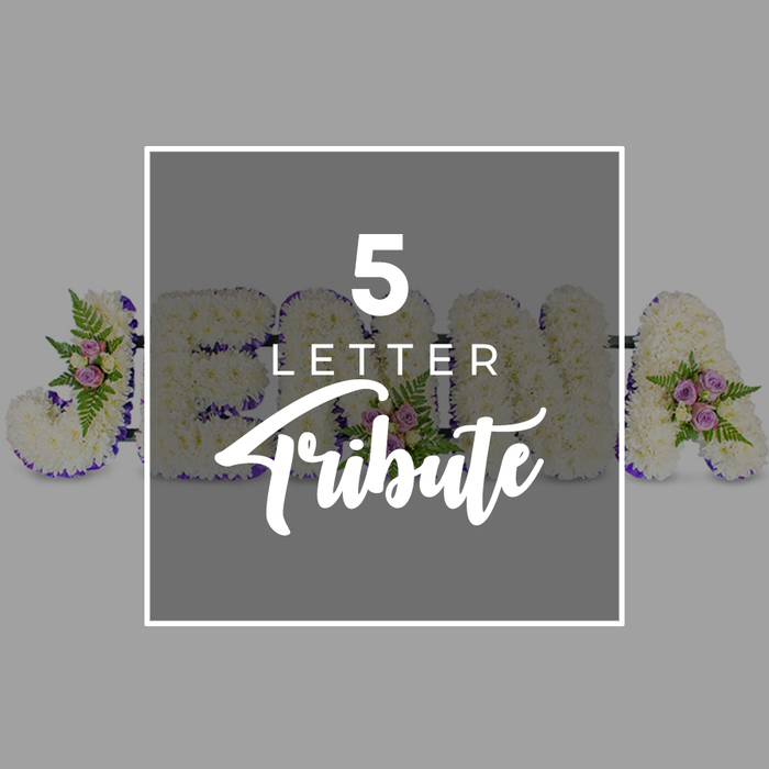A carefully composed overhead photograph captures a personalised five-letter funeral flower tribute arranged on a smooth, pale grey surface, the kind of bespoke design frequently requested by families in Gerrards Cross wishing to honour a loved one by name. The tribute is made up of five large capital letters placed in a row, each one completely covered with tightly clustered white blooms, most likely chrysanthemums or carnations, giving the letters a soft yet structured appearance. The petals form a dense, cushiony texture that looks both pristine and comforting. Around each letter, a border of deep purple satin ribbon runs in a continuous line, neatly folded and pinned to follow every curve and angle of the shapes, adding a refined frame and a subtle, regal tone. Here and there, delicate accent groupings of pale pink and lilac spray roses are nestled into the white base flowers, accompanied by sprays of verdant foliage and slender fern fronds, introducing gentle colour highlights that feel tender rather than bold. These small clusters sit slightly proud of the main surface, giving the tribute depth and a sense of living movement. A central square overlay in a slightly darker shade of grey partially covers the letters, edged with a narrow white frame. Upon this sits the phrase 5 LETTER Tribute, with the words 5 LETTER in a crisp uppercase font stacked above Tribute written in elegant script, clearly indicating this is a template for a personalised name or word. The visible shapes suggest the letters J, O, H, N, and A, hinting at an example name. The overall atmosphere is one of respectful quiet, echoing the kind of gentle, heartfelt goodbye that might be seen at a memorial gathering somewhere between the tree-lined streets near East Common and the peaceful surroundings of local Gerrards Cross cemeteries.