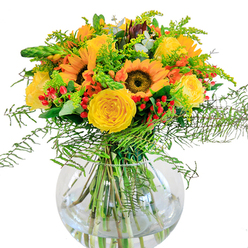 Central to this exuberant floral arrangement are grand sunflowers, each face alive with the sunny optimism of a Gerrards Cross summer's day. Their golden petals frame velvety brown centers, evoking open meadow vistas on the outskirts of town. Around them spiral lush, tightly packed garden roses-yellow as the midday sun-bringing both plush texture and timeless beauty. Scattered amid the blooms, sprigs of bright red Hypericum berries glimmer, offering surprise pops of colour that enliven the bouquet, like laughter shared on a stroll up Packhorse Road. Rich greenery provides a soft, feathery backdrop: layered ferns tumble and sweep downward, interspersed with slender, light green fillers bearing clusters of miniature yellow blossoms-possibly goldenrod, reminiscent of fields bordering the Gerrards Cross Memorial Centre. Eucalyptus leaves peek through, infusing the design with subtle blue-green accents and a sense of rustic authenticity. The bouquet stands proudly in a clear, rounded glass vase, its bowl-like shape cradling the carefully arranged stems and reflecting a purity akin to a peaceful walk in West Common woods. Designed for joyous milestones and thoughtful gestures alike, this arrangement delivers the vibrant energy of late summer right to your door in Gerrards Cross-perfect for brightening celebrations or simply enlivening your home with a touch of local floral artistry.
