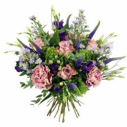 Captured against a clean, white background, this generous bouquet appears almost to float, its colours and textures carefully balanced by an experienced florist who knows how light falls in a Gerrards Cross sitting room on a bright afternoon. At its centre, velvety roses in blush pink and soft mauve open in graceful spirals, some petals touched with a slightly deeper pink edge that suggests the first flush of evening. Beside them, large carnations in dusty rose and muted purple contribute a ruffled fullness, their many layers overlapping like soft fabric, creating a sense of comfort and abundance. Slender Veronica stems in a saturated indigo-violet rise above the rounded dome of blooms, adding vertical movement and a painterly elegance, reminiscent of tall blooms seen in cottage gardens around Bulstrode Way. Between these structural elements, dainty, star-shaped aster-like flowers in lavender and periwinkle form airy clusters, their yellow centres lending a quiet brightness. Deeper purple lisianthus blooms, some open and some still in bud, tuck into the spaces, giving the composition a subtle, luxurious depth. Encircling the flowers is an array of fresh greenery: silvery eucalyptus leaves, sprigs of lively lime-green filler, and soft foliage that both frames and supports the blossoms. The bundled stems at the base reveal that this is a hand-tied design, ready for a vase or to be presented just as it is. The bouquet radiates a calm, romantic energy, suitable for thoughtful celebrations, gentle apologies, or as a refined floral gift delivered to homes and businesses throughout Gerrards Cross and nearby Denham, bringing a sense of quiet joy indoors.