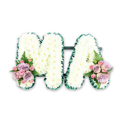 A lovingly detailed MA funeral letter tribute sits isolated against a clean white backdrop, allowing every petal and ribbon fold to stand out with clarity, as if arranged in the calm light of a Gerrards Cross chapel. The two capital letters, M and A, are formed from a sturdy base and then completely blanketed in white chrysanthemums, each flower closely set so that no gaps of foam or foliage show through. The chrysanthemums are small-headed and immaculate, their petals layered in tight circles, giving the letters a plush, cushion-like texture that invites a gentle touch. Around the outer outline of each letter, a dark emerald green satin ribbon is carefully pleated and pinned into a delicate ruff, the sheen of the fabric catching hints of light and providing a strong contrast to the softness of the white blooms. A coordinating dark green bar links the two letters discreetly at the bottom, holding them together as a single tribute, ready for placement at a service in Gerrards Cross or a nearby crematorium. At the base of the left side of the M and the right side of the A, compact mixed flower clusters bring understated colour and emotion. Pale pink roses and muted lilac roses are mingled with smaller pink spray roses, some in tight buds, others just beginning to open, their petals curved and silky. A few airy fern fronds extend beyond the clusters, adding fresh greenery and a sense of natural movement, like foliage from the wooded paths around Bulstrode Park. The overall colour palette-white, green, blush pink, and soft lilac-feels calm, respectful, and gently feminine, making this MA tribute a touching choice for honouring a mother, grandmother, or cherished Mama, thoughtfully crafted for local funeral flower delivery in Gerrards Cross.