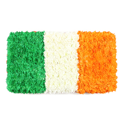On this table, a flag-inspired tribute breathes with the colours of Ireland. Flowing with green, white, and orange, the petals are arranged in three crisp vertical bands, each built from thousands of tiny flowers. The green band on the left forms a dense, emerald carpet-green carnations or chrysanthemums bending under the weight of the bloom, with little clusters creating a living texture. The center white stripe is a soft, cloud-like ribbon of petals, tight yet airy. The right-hand orange stripe glows with warmth, a mosaic of tiny blooms like marigolds or orange chrysanthemums. The white background accentuates the three stripes, their edges clean yet organic, as if grown rather than pressed. The design carries its symbolism: green for Catholic heritage and nationalism; white for peace; orange for Protestant tradition. It exudes a sense of calm celebration, a moment turned into memory. Displayed by Flower Delivery Gerrards Cross, it speaks to events that call for unity and remembrance-St. Patrick's Day, national holidays, or quiet moments of reflection. We offer it with careful handling and reliable delivery to residents and businesses across the area, from Station Road to the village green, ensuring freshness and prompt service. The result is not merely a decoration but a handcrafted tribute, a statement of heritage and craft that friends and families in Buckinghamshire can share.
