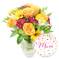 A lovingly arranged bouquet and celebratory balloon captured on a crisp white field, composed with the kind of care and local knowledge I bring to every Corsican-lilied stem when preparing orders for Gerrards Cross customers. The clear glass vase, simple and elegant, reveals trimmed green stems standing in fresh water and anchors the composition to the left. Dominant peachy-orange roses, their petals layered in soft spirals, radiate warmth and classic romance; yellow gerbera daisies punctuate the arrangement like cheerful sunbursts, their dark centres giving definition to each face. Ruffled burgundy carnations tuck in between the roses, providing rich, velvety contrast and fullness, while sprays of white alstroemeria add delicate, speckled highlights and a light, floral lift. Lush foliage in varied textures-broad glossy leaves and feathery sprigs-envelops the blooms and adds a garden-fresh backdrop. To the bottom right, a round white Mylar balloon leans gently against the vase: scattered gold and hot-pink polka dots and tiny hearts animate its surface, and "best Mum" is scripted across the centre in flowing hot-pink cursive. The arrangement reads as joyful and intimate at once, smelling faintly of rose perfume and feeling handcrafted. As prepared by Flower Delivery Gerrards Cross for local celebrations around the station and nearby Beaconsfield Road, it expresses appreciation and celebration in a way that's unmistakably thoughtful and appropriate for Mother's Day or a milestone birthday.