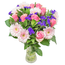 As I assemble this bouquet in our Gerrards Cross flower shop, each bloom becomes part of a luminous narrative reflecting the area's gentle rhythms-from the inviting charm of Packhorse Road to the quiet corners of Bulstrode Park. Soft, blush-hued gerbera daisies and perfectly formed pink roses blend seamlessly, their colours merging like watercolours on a spring morning in the village. Lively purple statice rises among the softer tones, offering pockets of deeper violet that evoke moments of cheerful surprise. Cool, verdant leaves form a lush underpinning, their dewy freshness reminiscent of early walks through East Common. Bound together and displayed in a simple glass vase, this bouquet glows with an easy confidence, the flowers positioned to maximize both natural grace and visual impact. Whether envisioned as a cheerful get well soon gesture delivered to a friend on Windsor Road or as a tasteful centrepiece in a Gerrards Cross home, every detail speaks to the careful expertise and joy we pour into our craft. This arrangement celebrates optimism and beauty, capturing the spirit of the local landscape and brightening any space with its soft, uplifting palette.