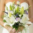 Brimming with a sense of anticipation, this bridal bouquet is a poetic masterpiece inspired by the tranquil beauty of Gerrards Cross-a gathering place where hope and artistry unite. White Oriental lilies unfurl with creamy radiance, their lush petals almost translucent in the gentle morning light reminiscent of springtime in the local parks. Unopened buds peek through, hinting at stories waiting to bloom. Feathery sprigs of asparagus fern and delicate clouds of baby's breath lend an ethereal air, as if the bouquet is floating on a soft breeze over Austenwood or the town's leafy backroads. Twists of lisianthus, their ruffled petals brushed lightly in lavender, swirl elegantly among the ensemble-each stem artfully positioned to create a sense of gentle movement and harmony. Rich purple spikes from Veronica or similar garden blooms add depth, their regal hues standing sentinel among more subtle whites and greens. This bouquet is both a tactile and emotional experience, exuding the gentle fragrance of lilies and fresh foliage, inviting thoughts of new journeys and heartfelt vows. It's a design made not just to impress, but to be held close-a Gerrards Cross floral creation that encapsulates the luminance and joy of a wedding morning.