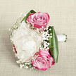 Captured on a pale, linen-like backdrop that feels calm and understated, this elegantly composed bouquet is arranged as if ready to be lifted straight from the photograph and carried to a wedding in Gerrards Cross. A single, luxurious creamy white peony forms the centrepiece, its petals layered in soft, billowing waves that invite the imagination to trace each curve. Framing this central bloom are two pink roses, their positioning - one gently above, one slightly below - giving the design a natural, flowing rhythm. Each rose begins with a modest blush at the core, swirling outward into petals that intensify into a richer magenta pink, lending a sense of depth and passion without overpowering the softness of the peony. Fine sprays of white baby's breath are scattered throughout the bouquet, their minuscule blossoms resembling tiny stars or snowflakes resting lightly among the larger blooms, adding texture and delicacy. Encircling the base, deep green, glossy leaves fold around the stems, their polished surfaces catching the light and providing a bold, structured contrast to the airy flowers. The stems are neatly wrapped in smooth white satin ribbon, creating a comfortable handle typical of a hand-tied bridal bouquet. One can easily imagine this arrangement being carried from a quiet home in Gerrards Cross down to a local church or civil ceremony, or arriving as a surprise anniversary gift delivered by a local florist. The bouquet's palette of creamy white, soft pink, and vibrant fuchsia conveys romance, joy, and sincerity, making it ideal for wedding collections, engagement celebrations, or heartfelt declarations of love.