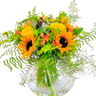 There's an unmistakable burst of optimism in this Gerrards Cross bouquet: golden sunflowers, every petal a tiny sunbeam, sweep upward from a bed of finely textured greenery. The duo of prominent sunflowers in front lights up the arrangement, their dark chocolate centers a grounding contrast. Bright, fluffy yellow filler flowers-possibly solidago-are woven throughout, their airy texture illuminated by the soft morning light filtering as though from a window overlooking East Common. Delicate coral-orange tulips and a sprinkling of eucalyptus add gentle vibrancy and a touch of modern flair. Cascading ferns trail beyond the edges, their lacy leaves echoing the natural elegance of local woodland glades. The clear, round glass vase reveals strong green stems, fresh-cut and immersed in water, emblematic of the high quality and care from Flower Delivery Gerrards Cross. This dynamic, cheerful bouquet suits heartfelt celebrations-a gesture of friendship, a congratulatory gift, or the perfect way to bring a sense of late-summer warmth into any home across Gerrards Cross.