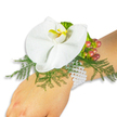 A refined wrist corsage rests gently on the fair-skinned wrist of a person, photographed against a spotless white backdrop so every detail reads clearly. At the center sits a large, pristine white Phalaenopsis orchid - its broad, satiny petals unfurling like a quiet, luminous moth. The orchid's labellum glows with a concentrated wash of bright yellow melting into a honeyed orange, a small sunburst that draws the eye and gives the bloom a gently warm heart. Beneath and around the flower, feathery asparagus-fern fronds fan out in lively chartreuse-green, their fine texture softening the composition and offering a natural cradle for the bloom. To the upper right, a small cluster of glossy Hypericum berries adds an autumnal punctuation: each berry carries a subtle gradient from pale green through flushed rose to a deep cranberry, suggesting movement and the ripeness of real botanicals. A whisper of ruffled lime-green foliage near the berries adds fresh contrast and layered texture. The arrangement is anchored by a multi-strand bracelet of lustrous white pearls that encircle the wrist with classical grace; their cool sheen complements the orchid's creamy petals and reinforces a timeless, heirloom feeling. Smooth skin, glossy pearls, soft fern, and the orchid's velvet surface create a tactile interplay that the eye can almost feel. As a local florist in Gerrards Cross might say, this elegant corsage is at once romantic and restrained-perfect for a wedding, prom, or any occasion where subtle luxury is desired-and would sit comfortably on High Street brides, graduates, or dancers stepping out from Gerrards Cross station into soft daylight.