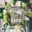 A pristine Florist Choice bouquet in white and lime sits elegantly on display, the kind that speaks of celebrations in Gerrards Cross with a quiet, confident charm. The most arresting feature is a cluster of large white lilies, their smooth, satiny petals curling outward as if catching a breath, their fragrance hinting at morning bells in our Buckinghamshire lanes. Surrounding them, generous blooms of pure white-likely ranunculus or roses-build a soft, cloud-like fullness that invites a closer look. Bright lime-green accents punctuate the arrangement, their crisp color and textural bite providing a contemporary counterpoint to the classic white, as if a modern sculpture had found its resting place among the stems. The lime clusters, likely Green Trick dianthus or compact lime hydrangeas, pulse with contemporary vitality, creating a bright contrast against the purity of the whites. A halo of dark green foliage-eucalyptus, ruscus, and other greens-frames the composition, lending depth and a touch of woodland elegance. The bouquet appears hand-tied, lifted by a person whose light dress is glimpsed in the softly blurred background, a hint of a wedding or formal event taking place in the village's quiet corners along The Broadway. Center stage is a clean white square, carrying the brand's message in two lines: at the top, the script-like word 'Florist' evoking craft, and below it, the uppercase 'CHOICE BOUQUET,' flanked by slender dash markers. The bottom line carries the price '?200' in bold, unmistakable figures, signaling a premium option for discerning gift-givers. This image communicates the florist's expertise-an expertly balanced blend of tradition and contemporary flair-and would be a refined choice for a wedding, anniversary, or thoughtful delivery across Gerrards Cross. It captures the freshness of a new day and the promise of reliable, same-day service from a trusted local studio.