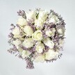 In this bouquet, there's a quiet grace reminiscent of a tranquil morning stroll down Packhorse Road in central Gerrards Cross. Crisp white roses form the heart of the display, each bloom plush, layered, and perfectly formed, with petals that spiral with the promise of new beginnings and gentle confidences shared over coffee in a local café. Sprays of pale lavender statice thread between the roses, adding a lace-like, feathery texture that brings gentle movement and visual intrigue to the arrangement. Set against a white-washed backdrop and illuminated by natural, soft light, every flower appears fresh, clean, and luminously alive-just as blossoms seem to glow in the first light streaming over the Common. Hints of clear green foliage ground the bouquet, echoing the verdancy found in Gerrards Cross's many gardens. The arrangement radiates a calm elegance, its structure both natural and thoughtfully ordered by local expert hands. Whether given as a symbol of comfort, to mark a serene celebration, or simply to elevate a favourite corner at home, this bouquet lingers in memory much like the scent of roses on an early summer breeze, offering a moment of brightness crafted for life in Gerrards Cross.