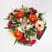 This radiant bouquet, as seen from above against a pure white backdrop, is alive with the spirit of Gerrards Cross in full bloom. Centered around glowing orange Gerbera daisies, each blossom bursts outward, evoking the sunrise over the town's peaceful greens. These are complemented by soft, creamy peach Gerberas with shadowy burgundy centers, bringing layers of depth like the varied shades of local flower beds. Between them nestle tightly wound magenta and fuchsia roses, joined by showy, hot pink ruffled carnations and the gentle surprise of soft white spray chrysanthemums, their tiny petals reminiscent of early summer wildflowers spotted on walks near Chalfont Park. Unopened white lily buds stretch upward, adding graceful lines and hinting at the future beauty held within. The bouquet is encircled by a fresh mix of greenery-from glossy broad leaves to slender eucalyptus-like sprigs-adding a cool crispness and sense of natural abundance. Every texture and colour in this arrangement has been selected to evoke joy, gratitude, and a sense of local celebration. Whether gifted for a birthday or to brighten a loved one's day in Gerrards Cross, this floral design feels like a cheerful embrace, fragrant with the subtle scents of rose and spring-fresh leaves-a perfect centrepiece for life's special moments.