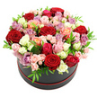 A sophisticated black hat box crowned with a dome of mixed roses takes centre stage against a spotless white backdrop, the contrast lending a gallery-like quality to the image. The box is round and matte, with a refined ring of red trim at its base, providing a subtle nod to the passionate crimson roses that anchor the design. Around and among these deep red blooms, a spectrum of colours unfolds: soft blush pink, spirited fuchsia, delicate cream and white, sun-warmed peach and coral, and cool lavender or mauve, all carefully arranged so that no single shade overwhelms the others. Large, open roses sit alongside clusters of dainty spray roses, some still in tight bud, creating an appealing rhythm of sizes and shapes. Small, bright green leaves are meticulously threaded through the bouquet, offering flashes of freshness that make the petals appear even more velvety by contrast. The overall shape is rounded and full, with the flowers slightly overflowing the edge of the hat box to give a sense of generosity and abundance. The lighting is even and soft, enhancing every detail without glare, as if the piece were displayed in a calm room in one of the elegant houses around Gerrards Cross town centre. The scene conveys a feeling of romance, celebration, and considered luxury, much like a surprise same-day delivery from a trusted local florist arriving at a door near the station or along Oxford Road. It suggests a perfect floral gift for anniversaries, birthdays, or heartfelt gestures when you want to say I love you in a beautifully crafted, modern way.