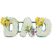 A deeply felt, three-dimensional memorial spelling 'DAD' in large, freestanding block letters, each letter lovingly built from a dense mattress of pristine white spray chrysanthemums that give a soft, cloud-like texture to the forms. The outer and inner contours are neatly finished with a ruffled dark green satin ribbon that reads as a crisp, elegant frame against the pure white blooms; the ribbon's satiny sheen catches the light and adds depth where shadows fall between the clustered florets. Behind the letters a slim dark green metal support bar runs horizontally, visible in places and reminding you of the careful craftsmanship that keeps the display steady at a funeral or chapel service. The left 'D' carries a bright accent at its upper curve: three to four sunlit yellow roses, opened to reveal warm golden centers, mixed with tiny white freesias and delicate foliage, a friendly, uplifting cluster from which two long, bare green stems arch gently toward the central letter. The central 'A' is anchored by a refined arrangement on its lower diagonal: two deep purple, almost burgundy, calla lilies with their sculpted, trumpet forms, set among more white accents and glossy green leaves, lending an air of quiet dignity. The right 'D' mirrors the left with another cheerful spray of yellow roses and white fillers. Presented against a plain white backdrop, this tribute balances purity, warmth and reverence - a design I would ready for a service in Gerrards Cross, deliver by hand to local churches or the crematorium, and arrange with the kind of care neighbours around the High Street expect when saying a final goodbye.