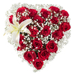 Set against a crisp white background, this heart-shaped floral composition reads like a quiet love letter rendered in blooms. Dozens of deep, crimson red roses-some in tight bud, others unfurling to reveal velvety, layered petals-are packed closely to form a clear, romantic heart silhouette. Between the roses, delicate sprays of baby's breath (Gypsophila) float like small clouds, their tiny star-shaped white florets softening the heart's edges and lending an airy, almost whispering texture that balances the roses' dense richness. Nestled in the upper-left curve is a single, sculptural white lily whose broad, pristine petals open like a small beacon; a faint wash of creamy yellow gathers toward its center, and slim yellow-orange stamens give a gentle punctuation of warmth. The arrangement's textures invite the senses: the powdery, velveteen touch of rose petals, the feathery lift of gypsophila, and the waxy smoothness of the lily, while a subtle floral scent-heady rose with a crisp, green lift from the lily-seems almost perceptible in the clean studio light. The composition is meticulously shaped, each bloom placed with precision to sustain the heart form and an overall sense of balance. This bouquet reads as an expert gesture of romantic devotion-suitable for Valentine's Day, anniversaries, intimate memorials, or any moment when affection must be made visible. The simplicity of the white backdrop allows the reds and whites to pop, emphasizing the designer's hand and the bouquet's emotional intent without distraction. A local florist's craft is evident in the controlled drama and tender detail of the piece.