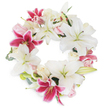 A serene and dignified circular wreath of locally arranged florals is displayed on a pristine white backdrop, capturing both beauty and respectful remembrance for those in Gerrards Cross. Dominating the composition are large white lilies, their trumpet-shaped blooms and pale green stamens creating a foundation of serenity, purity, and gentle grace reminiscent of tranquil mornings by Bulstrode Park. Interlacing these are vibrant fuchsia pink lilies, their vivid, star-shaped petals bringing warmth and rich accents-an echo of treasured summer blooms dotted throughout the Gerrards Cross gardens. Clusters of smaller blush and cream roses, some in bud, others delicately open, add a romantic softness and nuanced texture that invite quiet reflection. Wisps of muted green foliage, perhaps eucalyptus, peek from behind the flowers, lending a natural touch and sense of depth, much like the subtle greens found along local countryside lanes. The full, unbroken circle of blooms is artfully arranged to symbolize eternal memory, unity, and comfort, its overall effect both poignant and uplifting. Crafted with care by expert local hands, this wreath offers a meaningful expression of sympathy, ideally suited for funerals, memorials, or commemorative gatherings across Gerrards Cross-a refined tribute that honors, soothes, and endures.
