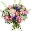 A lush, multi-textured bouquet is captured against a simple white backdrop, making the flowers and foliage the sole focus of the image, much like a single arrangement displayed in a bright Gerrards Cross townhouse. The design is hand-tied and pleasingly rounded, densely filled so that no gap feels empty, yet every blossom has space to breathe. Central to the composition are large rose heads in shades of antique pink, dusty rose, and soft peach, some fully open with intricate swirls of velvety petals, others still partially furled, bringing a sense of natural progression and life. Interspersed are generous blooms of ruffled carnations, their fringed petals creating a luxurious texture and a soft two-tone effect that moves from vivid magenta along the outer edges to a gentler, blush-toned centre. Tucked between these romantic tones are bold accents of indigo and violet-blue anemones, each flower bearing a dark central eye, adding striking contrast and a hint of drama within the otherwise pastel palette. Rising above the main body of the bouquet are slender stems of lavender and pale pink stock flowers, their many small florets clustered along upright stalks, contributing a delicate, feathery appearance and evoking the subtle scent of an early-morning garden walk around West Common. Surrounding the flowers, an abundance of greenery frames the arrangement: rounded, silvery eucalyptus leaves catch the light with a cool sheen, while deeper, broader green foliage anchors the design and amplifies the colours of the blooms. The natural stems are tightly gathered and left visible at the base, reinforcing the hand-crafted, freshly cut feel, as though just arranged for same-day delivery in Gerrards Cross to mark an anniversary, offer thanks, or gently brighten someone's day with sophisticated yet relaxed beauty.