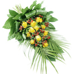 A long, graceful sympathy spray is shown laid flat against a white background, its design gently tapering from a structured, leaf-filled top left corner towards a narrower, flowing tip at the lower right, much like arrangements prepared for quiet farewells in Gerrards Cross. Central to the piece are numerous yellow roses, their petals carrying the soft, golden tone of late afternoon sunlight. Some roses appear in tight buds, others partially open, and a few in full bloom, revealing velvety, layered centres that suggest affection and enduring memory. Threaded between these blooms are many small, round red Hypericum berries, their deep colour and smooth sheen providing a striking contrast that adds texture and visual rhythm. Encasing the flowers is a carefully arranged framework of greenery. At the upper left, large, dark green leaves have been folded and wrapped to form a supportive base, giving the spray a composed, almost architectural presence. As the eye moves downward, medium-green foliage fills the body of the arrangement, creating lush volume. From the lower right, several slender palm-like fronds stretch outward, their narrow, pointed leaflets lending a light, airy finish that echoes the gentle swaying trees one might see near local resting places off Oxford Road. The stems are neatly gathered and secured out of sight, making the spray suitable for resting on a coffin top, memorial stand, or graveside. With its harmonious blend of warm yellow, deep green, and dignified red, this design conveys a quiet message of respect, comfort, and farewell for loved ones remembered in and around Gerrards Cross.