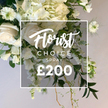 Flower Delivery Gerrards Cross presents this lush white and cream spray, a statement piece rooted in the quiet elegance of our town. The arrangement is presented against a soft, light backdrop, the kind you see in a showroom on The Broadway, and the bouquet whispers luxury without drama. It features prominent soft white roses-some buds tightly furled, others opened-paired with big, cloud-like hydrangeas that give body and a creamy halo. Delicate white sweet peas or cascading blossoms trail gracefully downward, adding gentle movement as if caught in a late spring breeze. Nigella Love-in-a-Mist adds slender green centers and feathery petals, tucked among lush green foliage that ranges from deep satin leaves to lighter variegated tones and delicate, curling fronds. The composition feels garden-made yet curated, as if plucked from a sunlit corner of Gerrards Cross's own green spaces or a market stall along The Broadway. A clean white square frame sits over the center, containing Florist Choice in a flowing script, then SPRAY in bold, and a prominent price of £200 at the bottom. The overall impression is one of premium craftsmanship, designed for elegy, anniversary, or a refined home display. This spray is prepared with fresh stems from local growers and available for timely delivery across Gerrards Cross and the surrounding villages, ensuring the recipient experiences the same care you would expect from a trusted local florist.