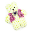 Captured against a spotless white background, this floral teddy bear tribute appears as a tender symbol of innocence and remembrance, much like the quiet, comforting corners of Gerrards Cross where families gather to say goodbye. The bear's form is meticulously sculpted using hundreds of fresh white chrysanthemums, each tiny blossom nestled so closely that the surface resembles soft, brushed fur. Gentle touches of cream within some petals add dimension and warmth, making the figure look especially inviting. The head is rounded with two clearly defined ears at the top, and the simple facial features are delicately composed: two small, dark eyes and a neat black nose create a look of gentle calm, while a subtle curve at the mouth suggests a peaceful, knowing smile. Draped across the chest is a colourful floral waistcoat, made from deeper-hued flowers in shades of magenta, pink, and lilac, reminiscent of blooms picked from an English cottage garden. These flowers are set in dense clusters, creating a rich band of colour that stands in charming contrast to the pale body. At the neckline, a fine purple net bow provides the finishing touch, its airy loops and tails adding an elegant, almost playful detail that softens the formality of a funeral display. The even lighting and simple backdrop draw attention to the craftsmanship: every curve, petal, and transition between colours is clear and intentional. Suitable for a child's memorial, a baby's farewell, or a gentle remembrance service, this floral teddy bear conveys love, comfort, and the careful attention of a local Gerrards Cross florist who understands the significance of such tender tributes.